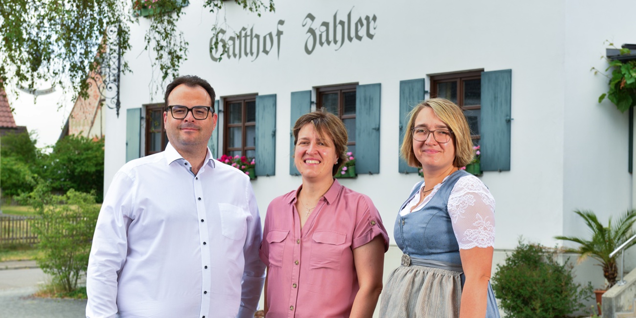 Drei Personen stehen nebeneinander
